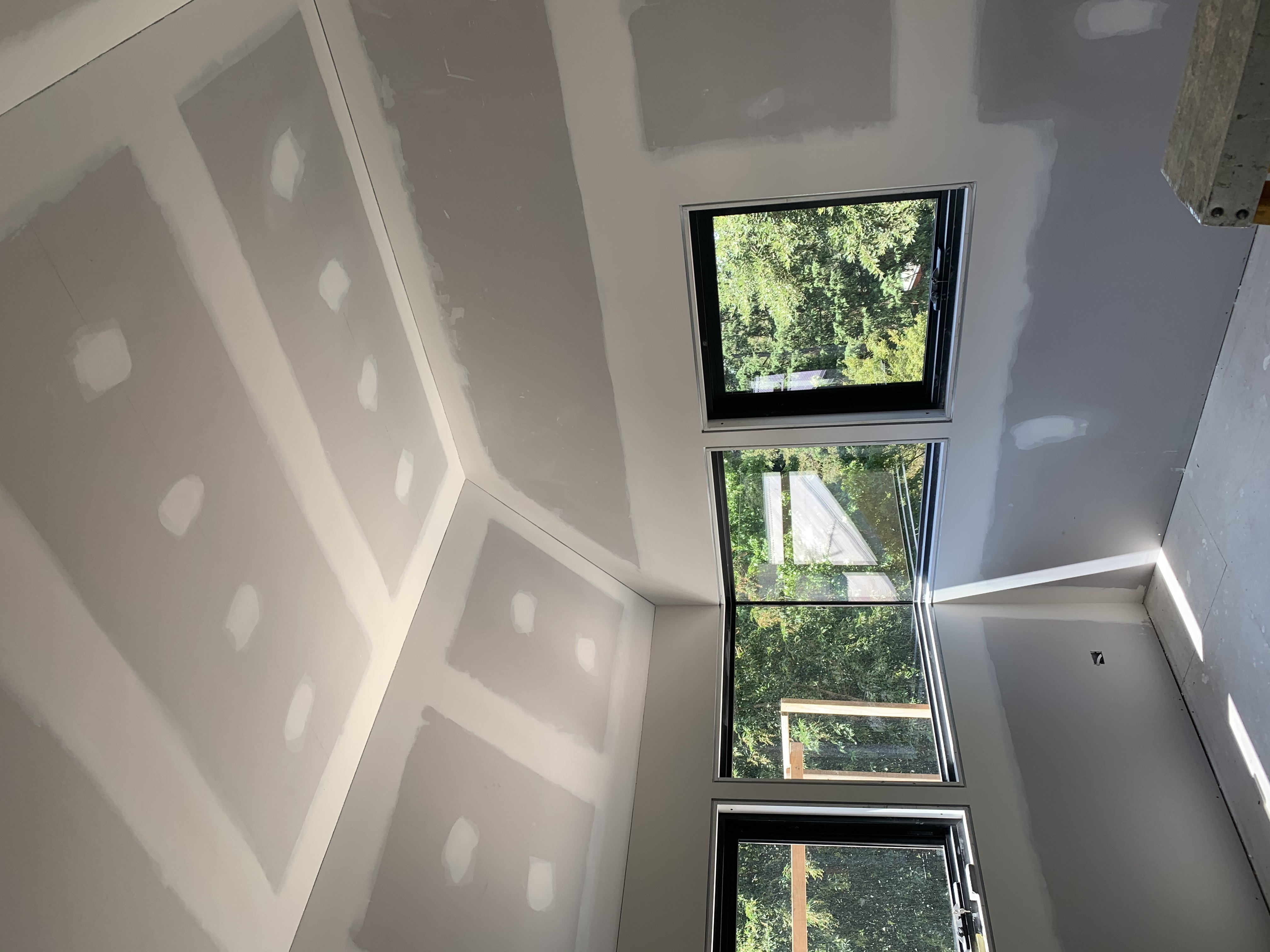 Interior plasterboard room with tall window